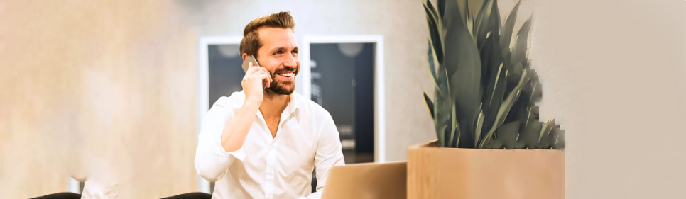 Guy on phone with laptop and plant